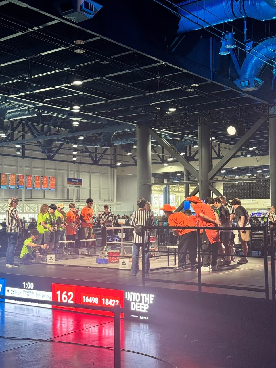 A competition field at the FIRST Championship. The scoreboard lists team 18422 in the red alliance during an INTO THE DEEP match.